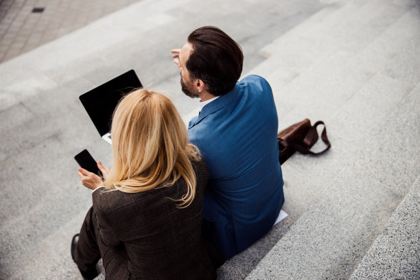 一个拿着手机的女人和她的同事图片下载