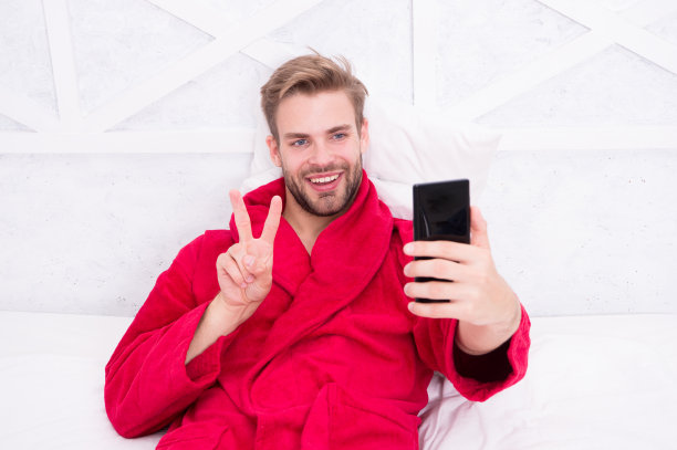 在社交网络上冲浪的男潮人。在线交流。手机依赖。社交网络沟通。数字通信。检查电子邮件。和朋友聊天。早上的仪式图片下载