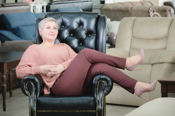 中年妇女的肖像。这家家具公司的老板兼董事正微笑地坐在一张昂贵的黑色皮革扶手椅上。捷径坚强的女性图片下载