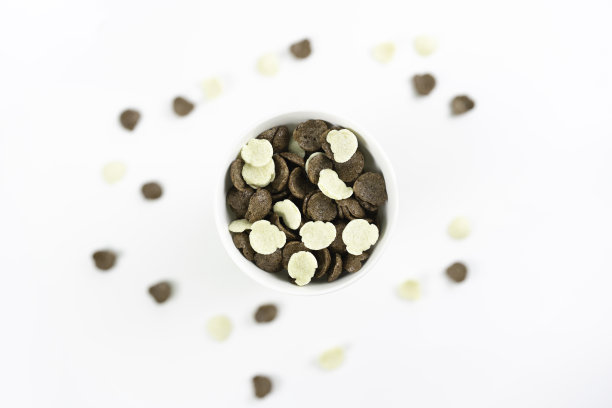 碗里的可可粉嘎吱作响，孤立在白色的玉米粒上图片下载