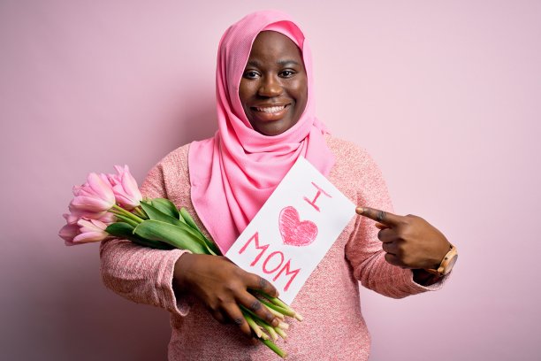 大尺寸的非洲裔美国妇女戴着头巾，手持短信和郁金香在母亲节非常幸福的手指和手指图片下载
