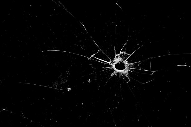 黑色背景上玻璃上的洞和裂缝图片下载