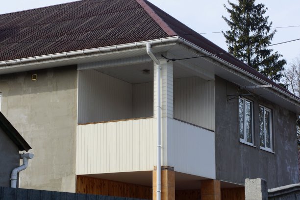 一座私人住宅的灰色墙壁上有一个开放式的白色塑料阳台图片下载