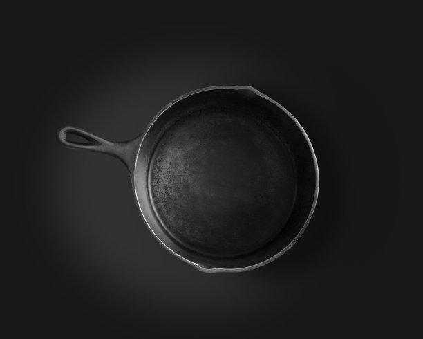 黑色背景的大型熟透的铸铁平底锅图片下载