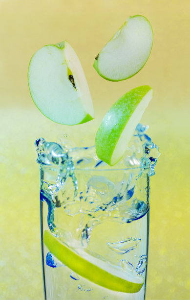 一杯黄色背景上有飞苹果的水。三维演示图片下载