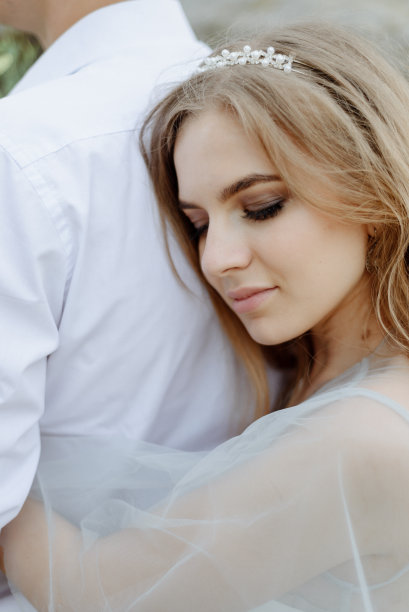 一对情侣在山上相爱的照片。这个女孩打扮得像个穿着婚纱的新娘。图片下载