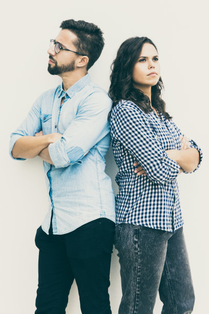 一对不幸的夫妇背靠背，双臂交叉图片下载