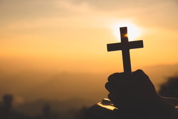 一名基督教妇女手持十字架向上帝祈祷的手。宗教信仰，复制空间。图片下载