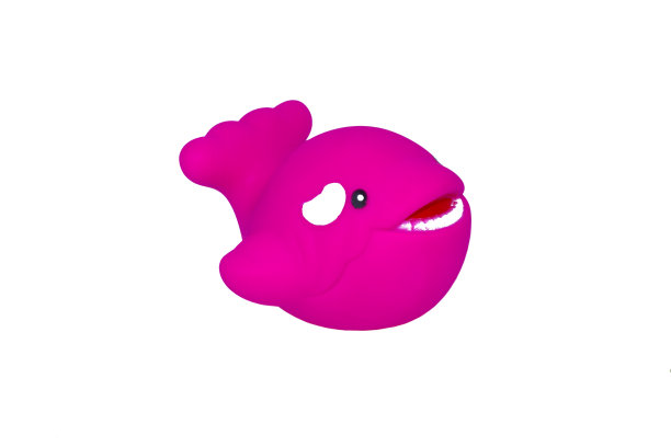 粉红色微型橡胶玩具的鲸鱼孤立在一个空的白色背景图片下载