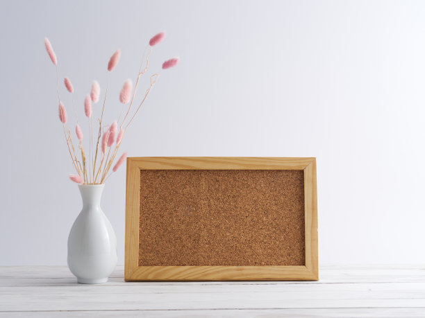 木制框架模型与粉红色的草花花瓶在白色木桌上。图片下载