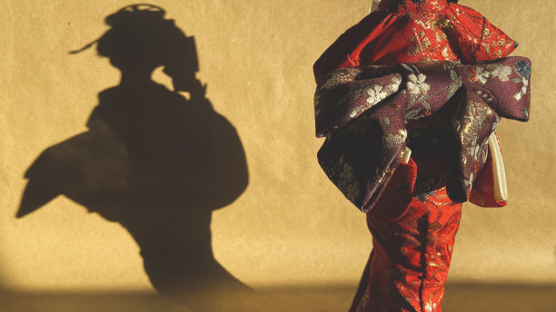 日本艺妓的剪影。小雕像的影子在背景上。木偶剧院图片下载