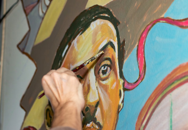 画家在起作用。拿着画笔的手的特写。图片下载