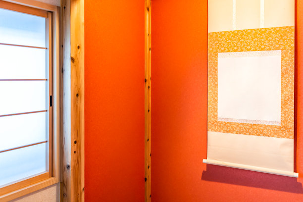 传统的日本红房子或日式旅馆，有窗户和壁龛，壁龛上挂着日式卷轴和橘红色的朱砂黄色图片下载