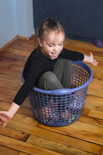 孩子坐在洗衣篮里图片下载