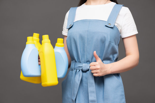 手中拿着洗洁精瓶。图片下载