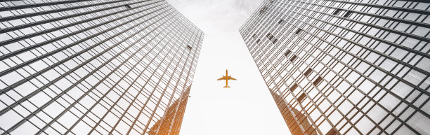 飞机飞越两座对称的城市建筑图片下载