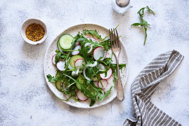 混凝土背景下的蔬菜沙拉，有芝麻菜、萝卜和黄瓜图片下载