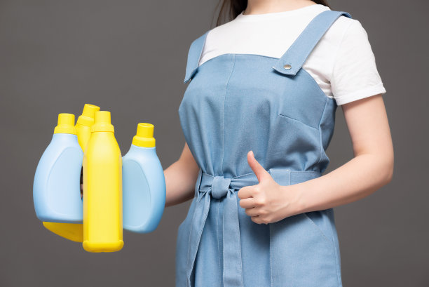 手中拿着洗洁精瓶。图片下载