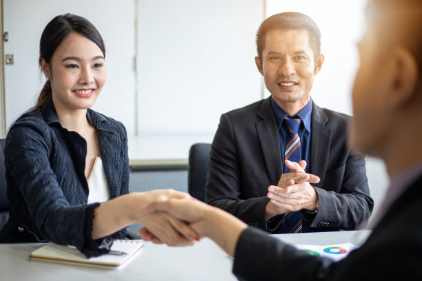 亚洲商人们微笑着握手表示同意签订合同并结束会议图片下载