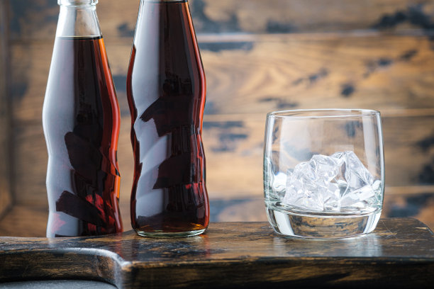 用可乐倒空透明的玻璃杯和瓶子图片下载