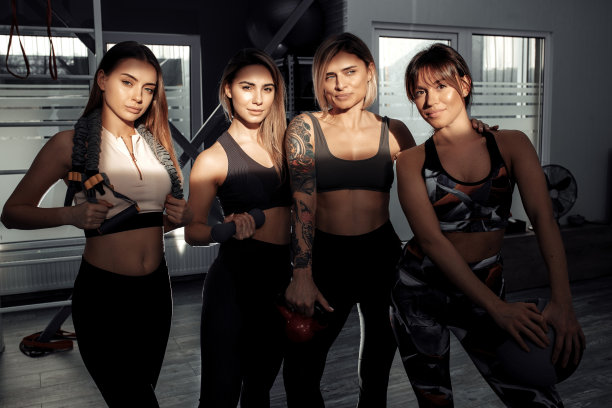 四个年轻的运动女孩站在一起放松后健身课。图片下载