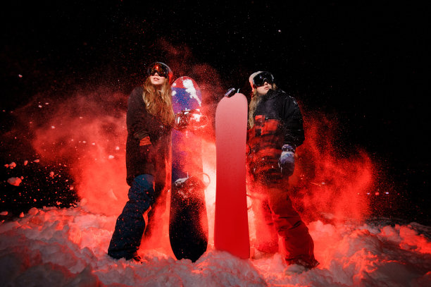 两个女孩拿着滑雪板站在雪山上图片下载