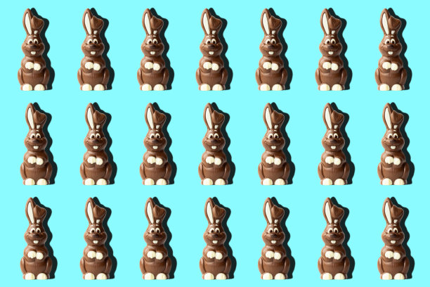 时髦的复活节图案，巧克力兔子在浅蓝色的背景在最小的风格。图片下载