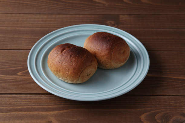 全麦面包放在盘子里，放在木桌上图片下载