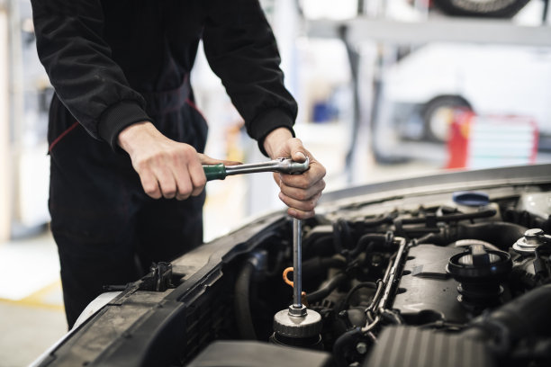 汽车修理工在汽车服务中修理汽车发动机。图片下载