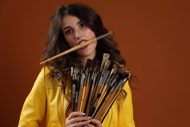 一个牙齿里叼着油漆刷的漂亮女孩图片下载