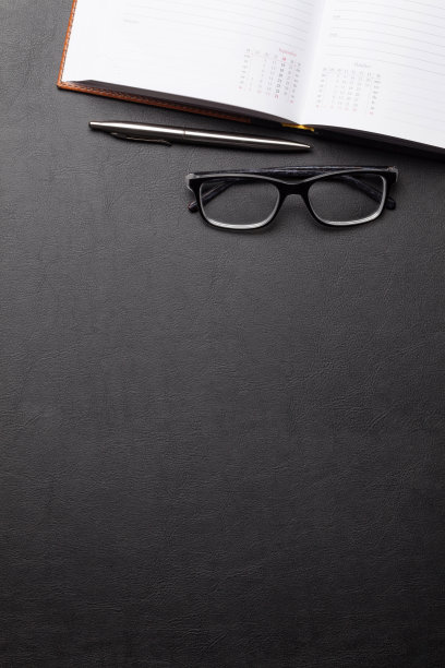 办公桌子，装有办公用品和眼镜的桌子图片下载