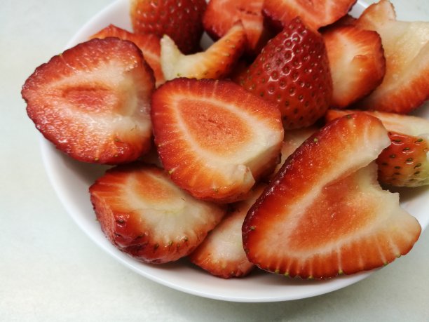 把草莓分成两半放在盘子里图片下载