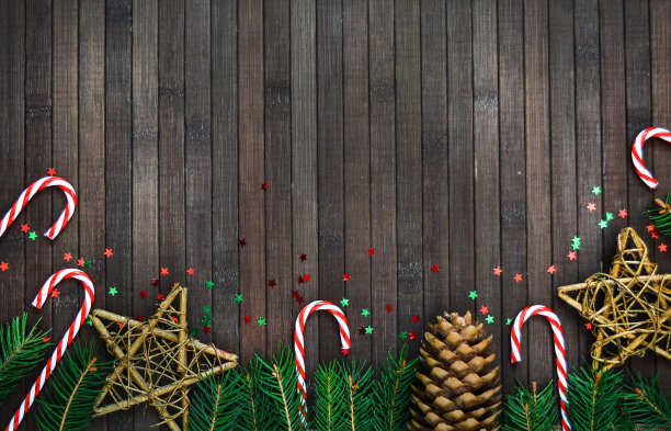 圣诞作文一树枝，圣诞老人帽，糖果星星，松果，在木制的背景。新年假期、圣诞节的概念。新年假日模式。副本的空间。图片下载