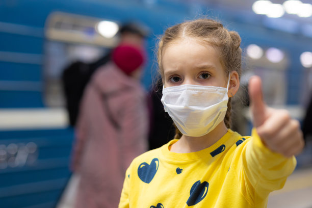 高兴、快乐、美丽快乐的孩子们戴着医疗保健护卫或保护口罩，穿着黄色t恤在地铁或地下大厅里图片下载