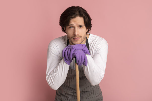 春季大扫除后，疲惫的男人倚着拖把把手图片下载