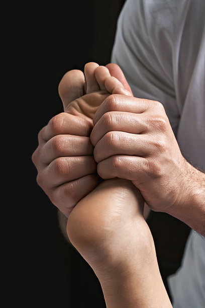 男按摩师在水疗沙龙为女性足部进行按摩图片下载