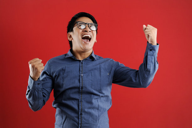 年轻的亚洲男子高兴和兴奋表达获胜的姿态。成功和庆祝图片下载