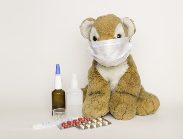 儿童药物。柔软的儿童玩具老虎在医用一次性口罩上的白色背景。药品和药片就在附近。儿童健康与疾病概念，保护儿童免受病毒侵害。图片下载