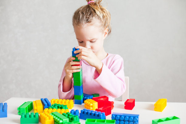 小女孩在玩五颜六色的塑料构造器图片下载