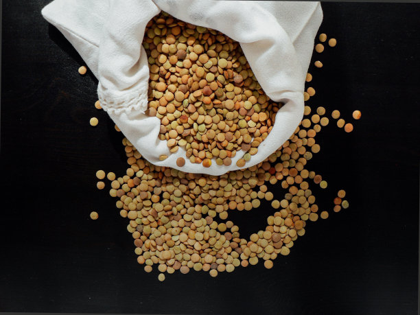 干的生鹰嘴豆放在棕色粘土碗里，放在木头上图片下载