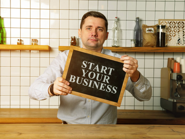 商人举着“开始你的小生意”的牌子。图片下载