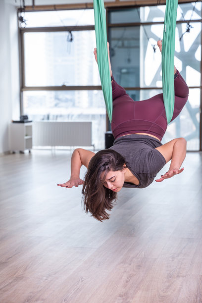 年轻女子在室内练习瑜伽的照片。美丽的女孩在课堂上练习瑜伽。瑜伽老师。模糊的背景图片下载