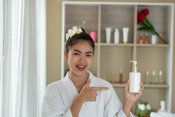 美丽年轻的亚洲女性手持并呈现白色的化妆管，美丽的护肤理念图片下载