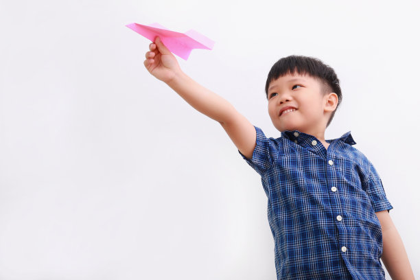 可爱的亚洲男孩玩纸飞机图片下载