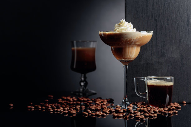 鸡尾酒咖啡，甜点和浓咖啡在黑色的反光背景。图片下载