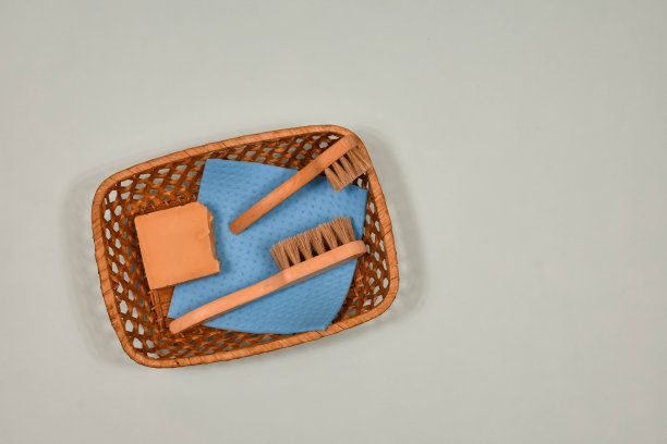 木制刷子和固体天然肥皂在篮子里在蓝色的背景。塑料产品的零替代品。环保的概念图片下载