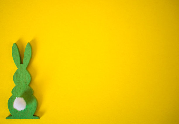黄色背景上的绿色复活节兔子。复活节黄色背景图片下载