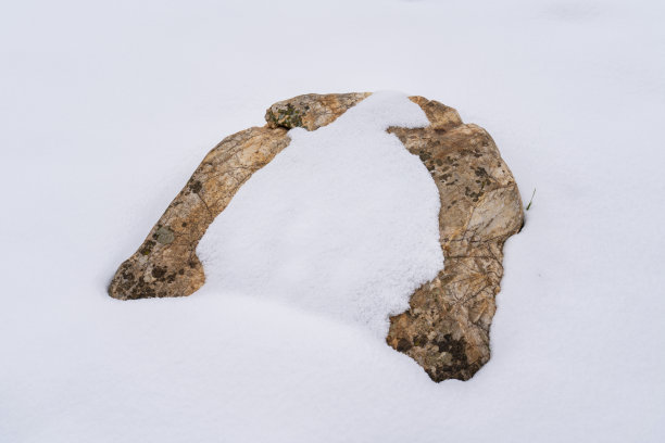 被雪覆盖的石头。图片下载