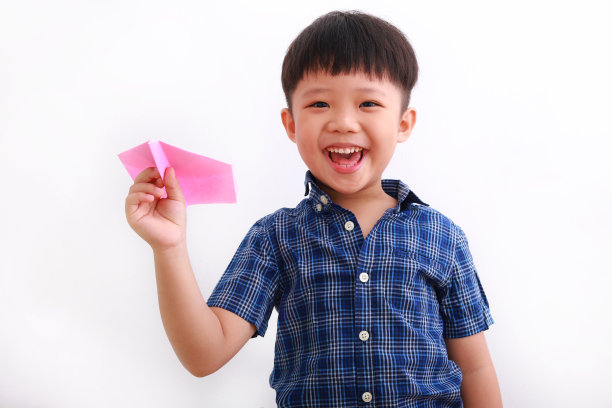 可爱的亚洲男孩玩纸飞机图片下载