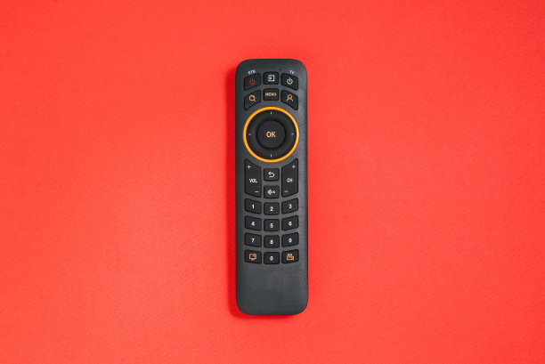 带有红色背景按钮的遥控器。智能电视的概念。家庭娱乐。图片下载